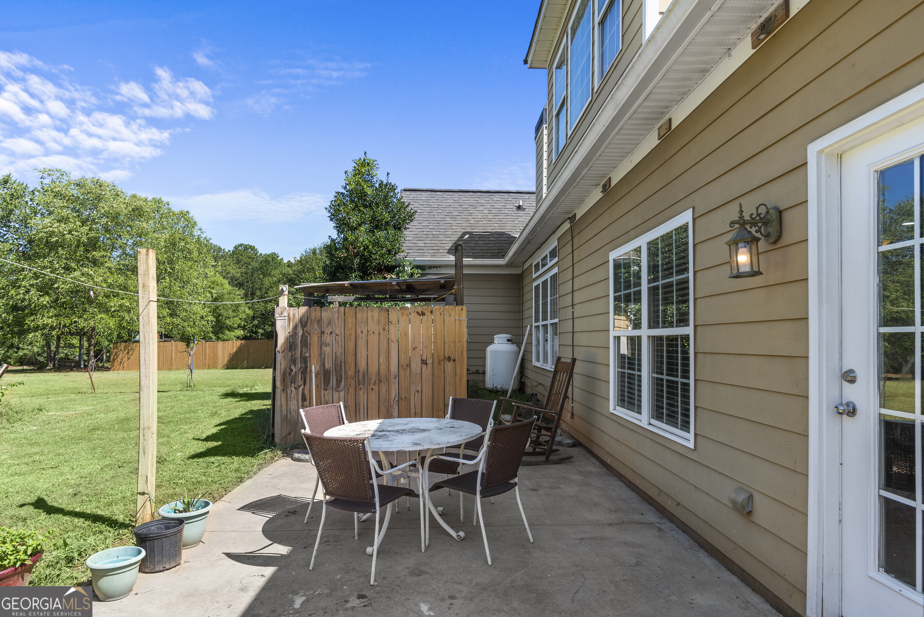 1141 Whispering Lakes Trail Madison, GA 30650 - Photo 35 of 40 a backyard of a house with table and chairs