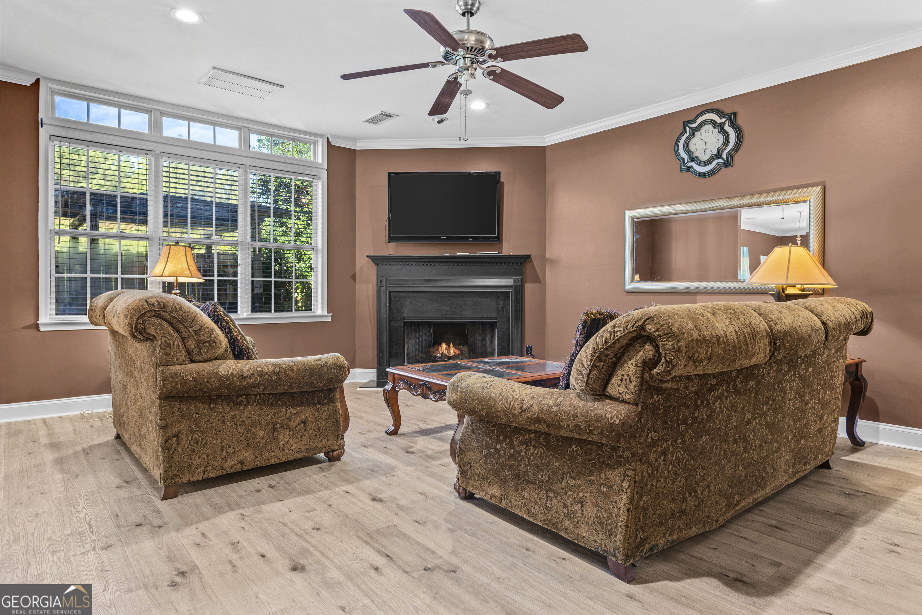 1141 Whispering Lakes Trail Madison, GA 30650 - Photo 4 of 40 a living room with furniture a flat screen tv and a fireplace
