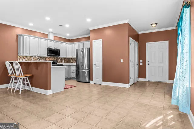 a kitchen with stainless steel appliances granite countertop a refrigerator and a stove top oven