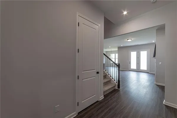 a view of a hallway with wooden floor and a bathroom