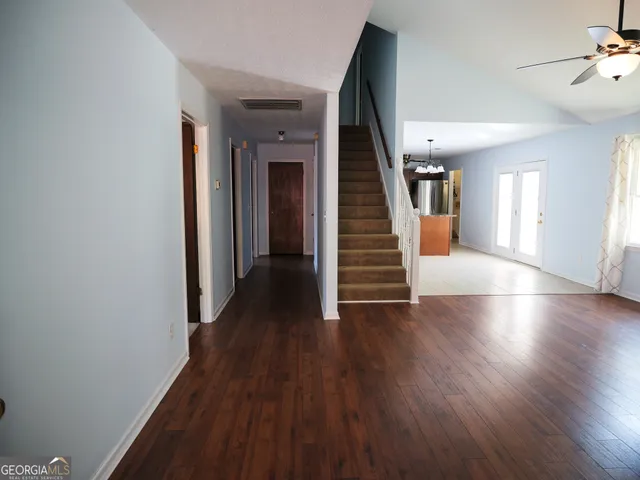 a view of a hallway with wooden floor and stairs