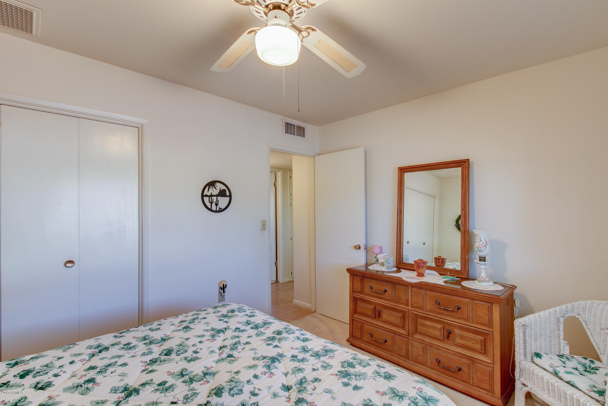 10008 West Riviera Drive Sun City, AZ 85351 - Photo 20 of 26 a bedroom with a bed and a mirror on dresser