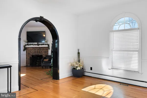 a view of a livingroom with wooden floor and a fireplace