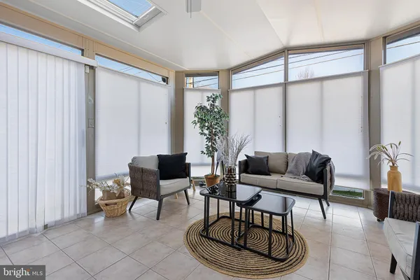 a spacious bedroom with a bed a mirror on dresser and a wooden floor