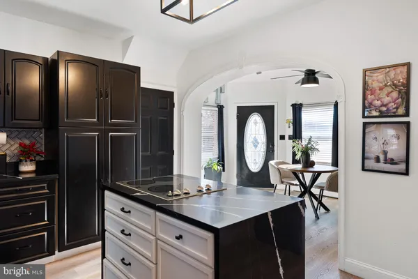 a dining hall with stainless steel appliances kitchen island granite countertop a stove a sink and a refrigerator with wooden floor