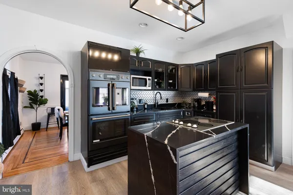 a kitchen with stainless steel appliances granite countertop a stove refrigerator and cabinets