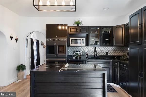 a kitchen with stainless steel appliances granite countertop a sink and a stove