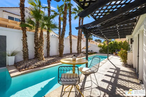 a swimming pool with outdoor seating and yard