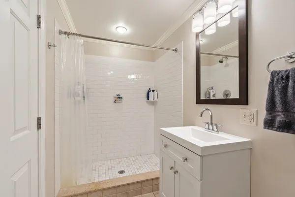 a bathroom with a shower sink and mirror