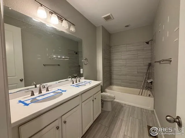 a bathroom with a double vanity sink toilet mirror and shower