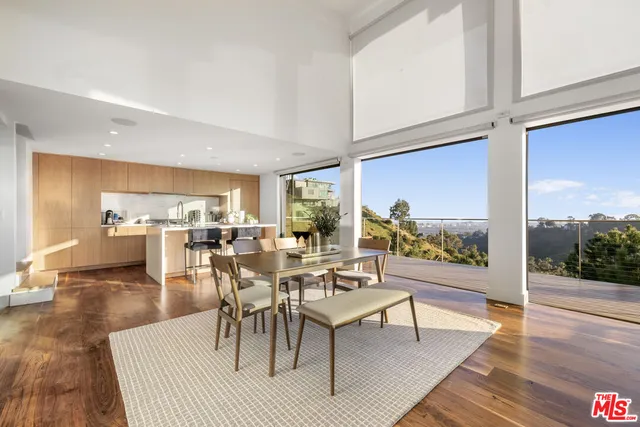 a dining room with wooden floor a glass table and chairs