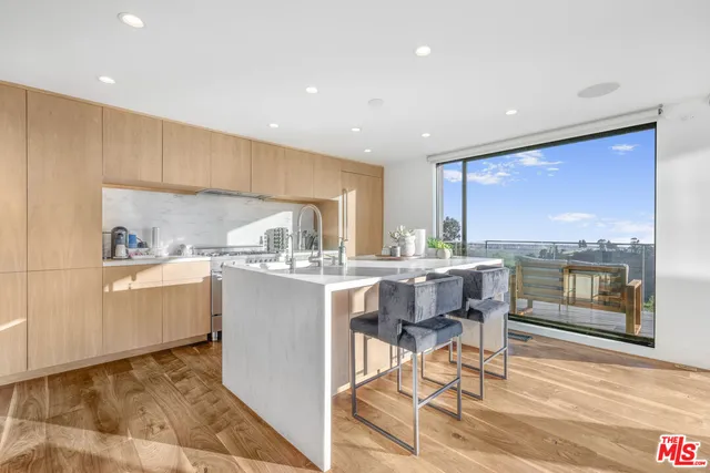 a kitchen with a dining table chairs and refrigerator