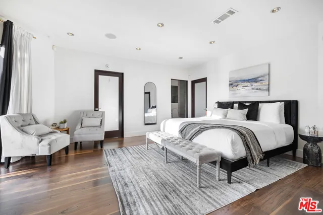 a bedroom with a bed and wooden floor