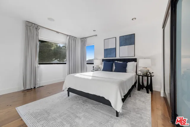 a bedroom with a bed table and window