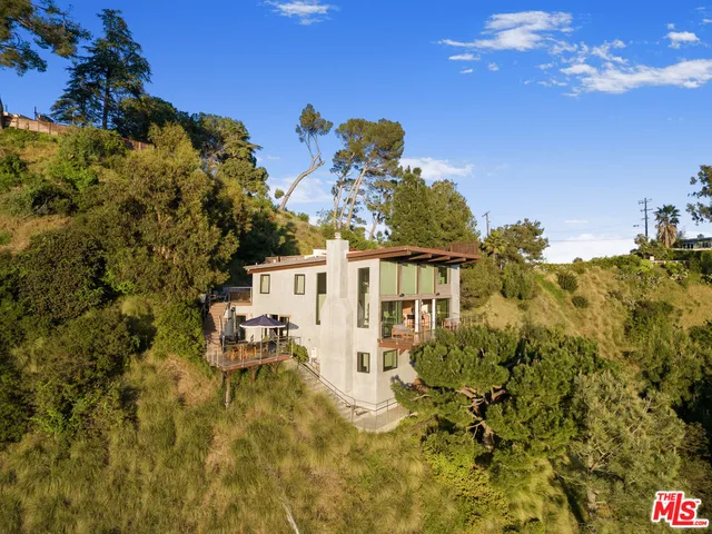 a view of two chairs in a backyard of a house