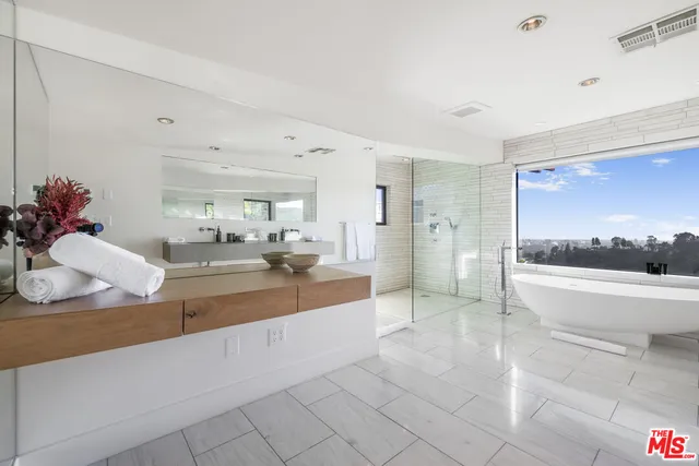 a large white kitchen with a large window and stove
