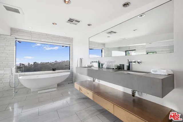 a bedroom with a bed and large windows