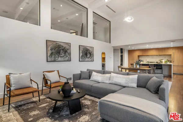 a living room with furniture and view of kitchen
