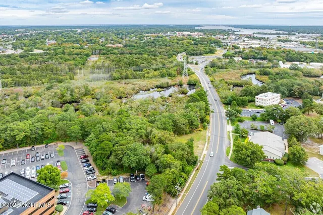 an aerial view of residential houses with outdoor space and trees