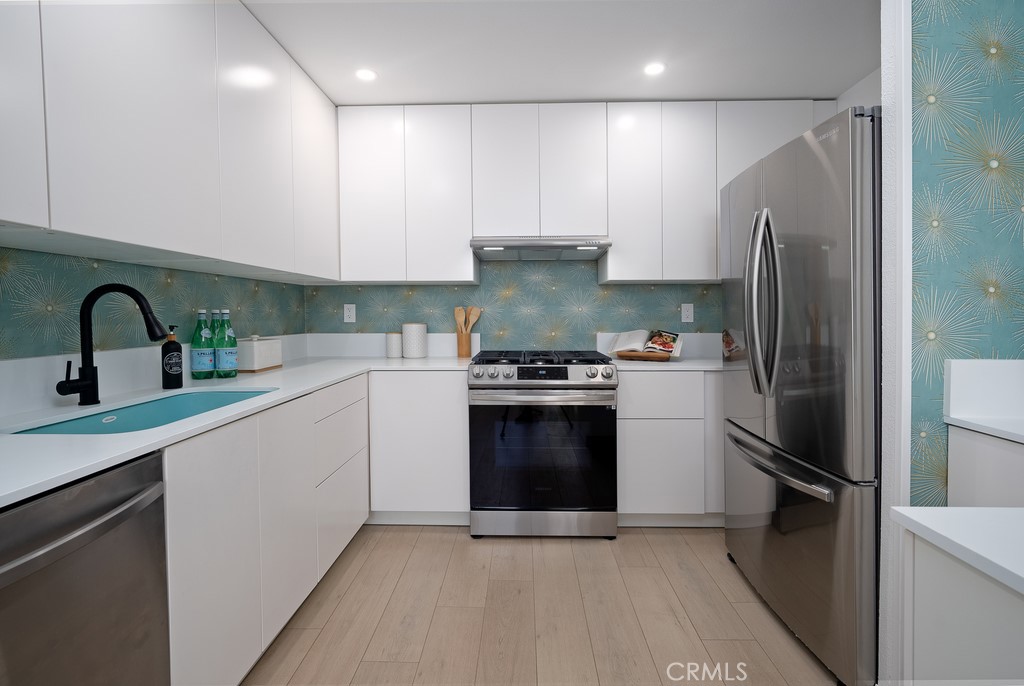 200 East Racquet Club Road, Unit 24 Palm Springs, CA 92262 - Photo 4 of 21 a kitchen with a refrigerator sink and stainless steel appliances
