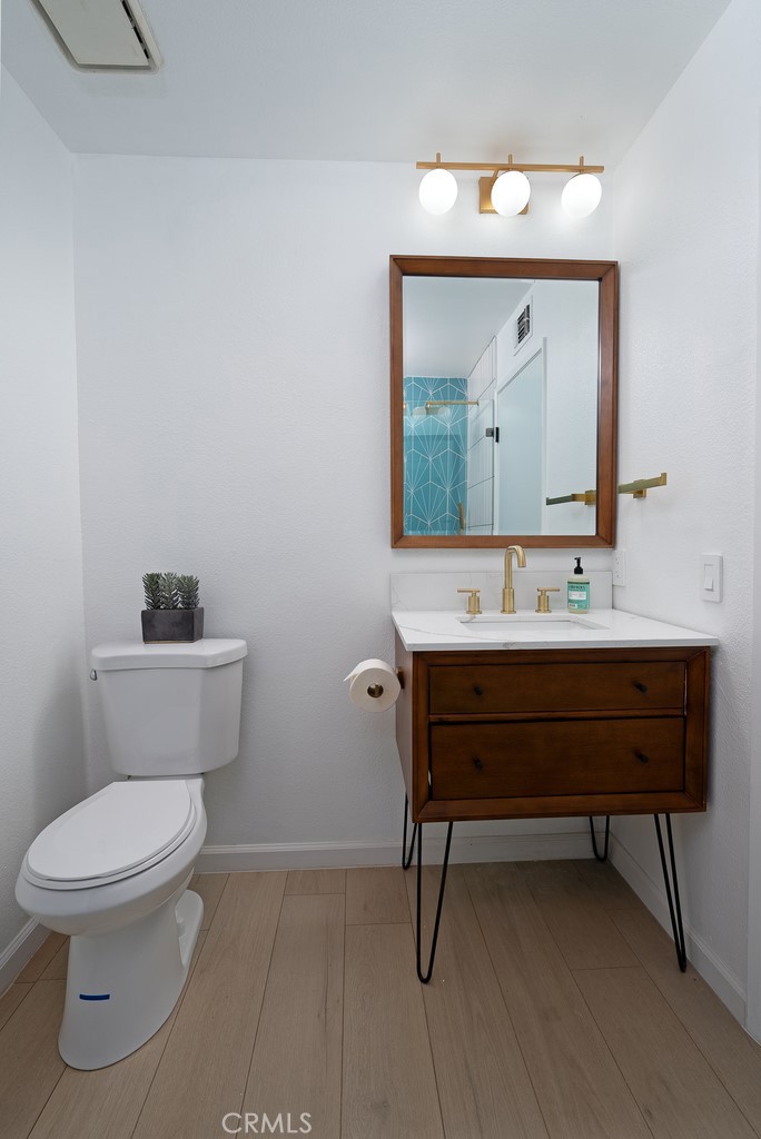 200 East Racquet Club Road, Unit 24 Palm Springs, CA 92262 - Photo 10 of 21 a bathroom with a toilet a sink and mirror