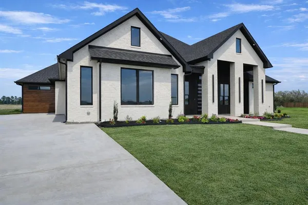 a kitchen with granite countertop a stove a sink dishwasher and a refrigerator with wooden floor