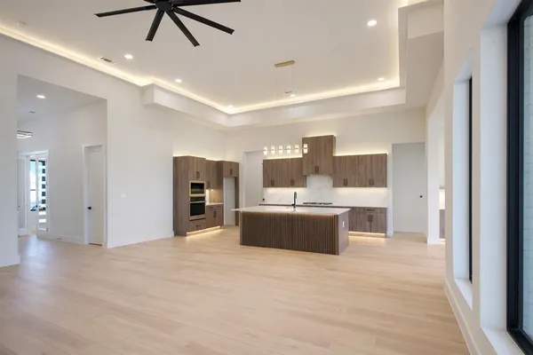 an empty room with a window and a ceiling fan