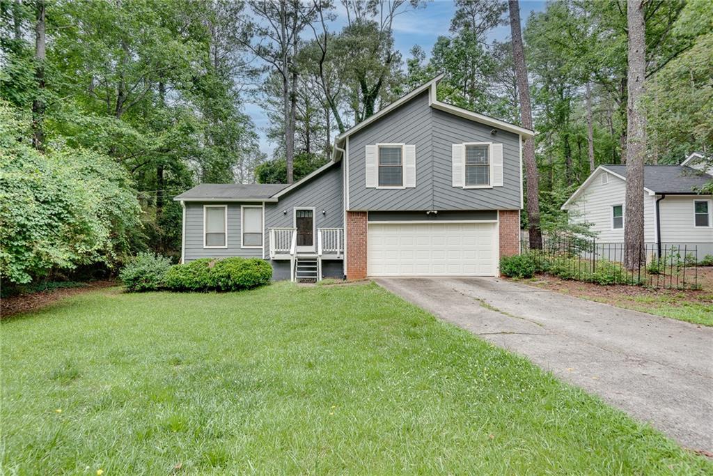 5611 Whittondale Road Lithonia, GA 30058 - Photo 34 of 34 a view of a yard in front of a house with plants and large tree