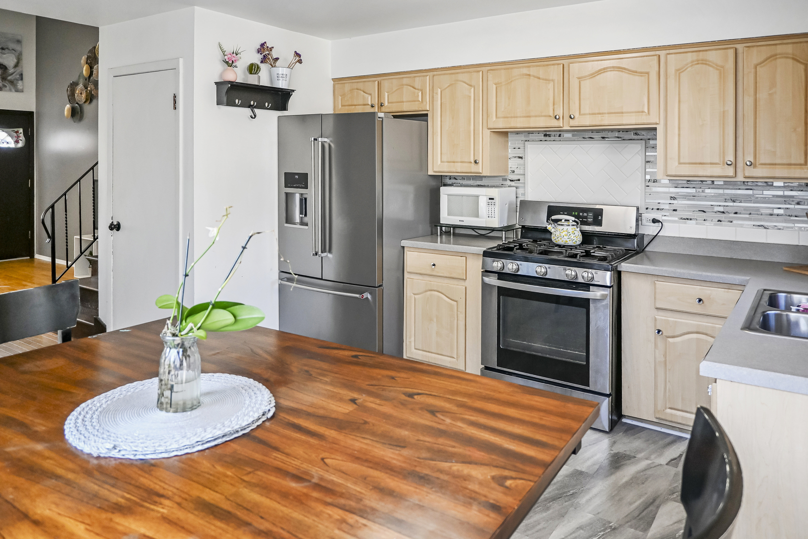 15115 Springfield Avenue Midlothian, IL 60445 - Photo 7 of 18 a kitchen with stainless steel appliances granite countertop a refrigerator a stove a sink and a dining table