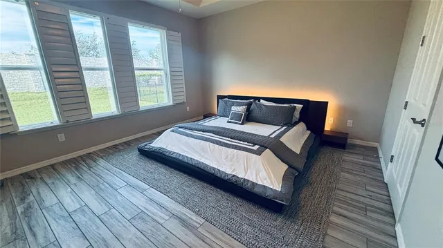 a bedroom with a bed and wooden floor