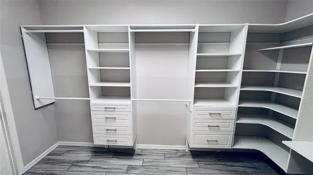 a view of walk in closet with empty racks