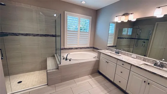 a spacious bathroom with a double vanity sink a large mirror and shower