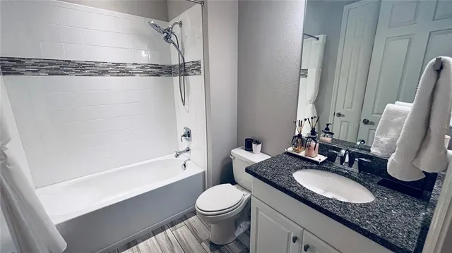 a bathroom with a granite countertop sink toilet and shower