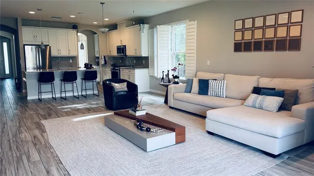 a living room with furniture rug and kitchen view