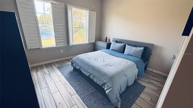 a bedroom with a bed and wooden floor