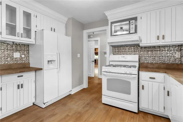 a kitchen with cabinets and wooden floor