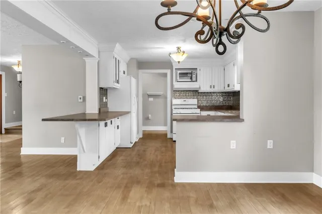 a view of kitchen with stainless steel appliances kitchen island refrigerator stove and microwave