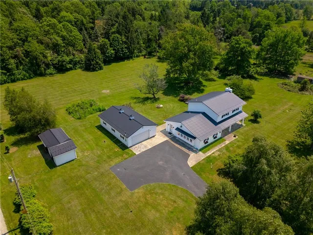 an aerial view of a house with garden space and a lake view