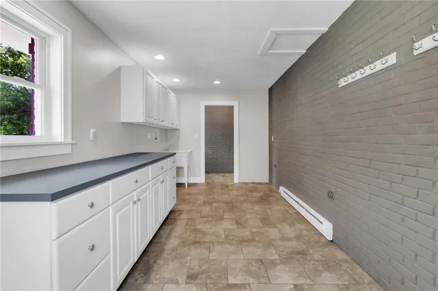 a large kitchen with granite countertop white cabinets and a sink
