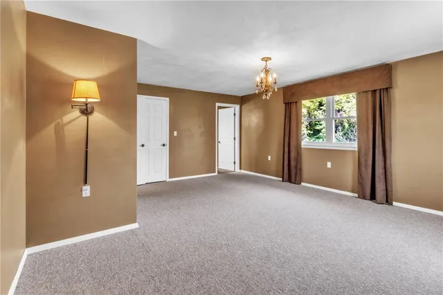 a view of a bedroom with a chandelier fan and windows