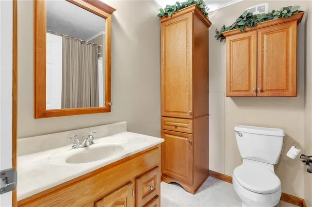 a bathroom with a granite countertop toilet sink and mirror