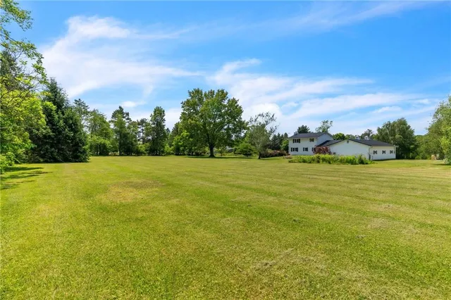 a view of a green field with wooden fence