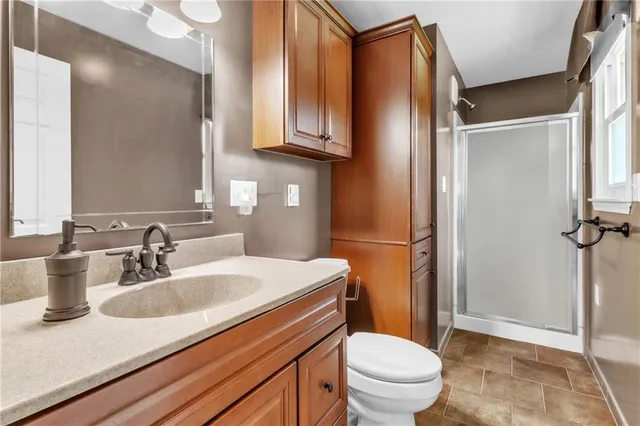 a bathroom with a sink a toilet a mirror and shower