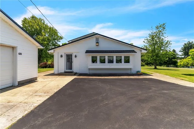 a view of a house with a yard and potted plants