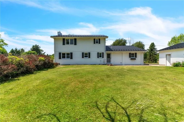 a view of house with a big yard and potted plants