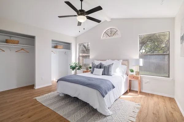 a spacious bedroom with a bed and a ceiling fan