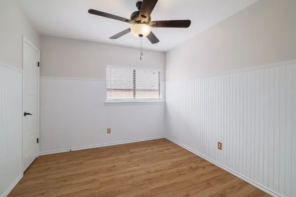 a view of empty room with wooden floor