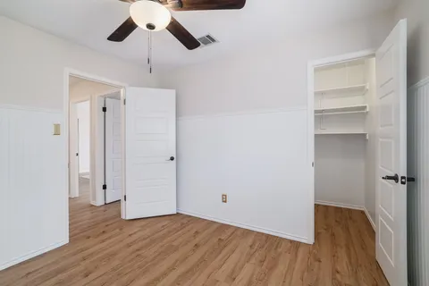 a view of empty room with wooden floor