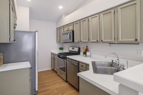 a kitchen with stainless steel appliances granite countertop a sink stove and refrigerator