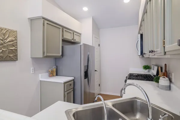 a kitchen with stainless steel appliances a sink a refrigerator and cabinets